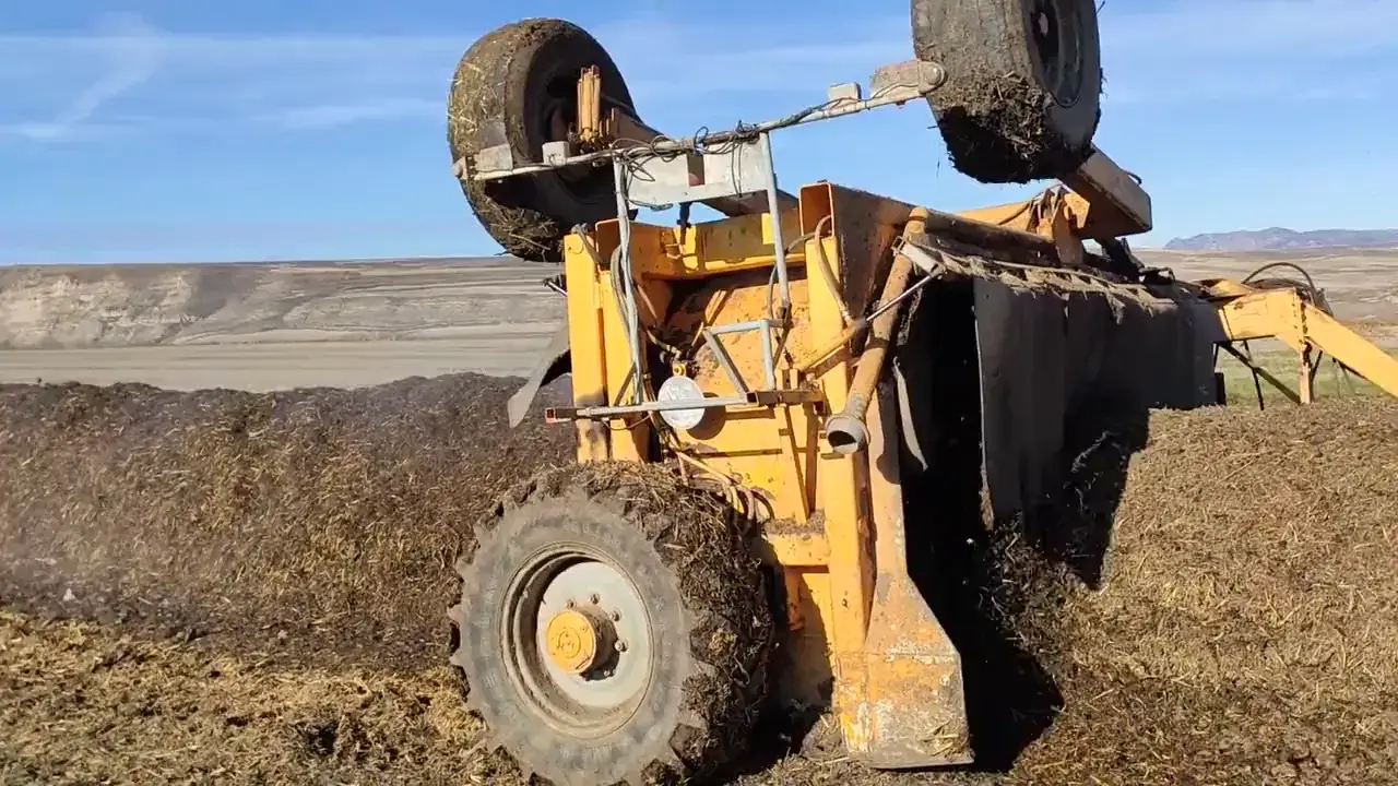 Volteadora mezclando una pila de bokashi en el campo