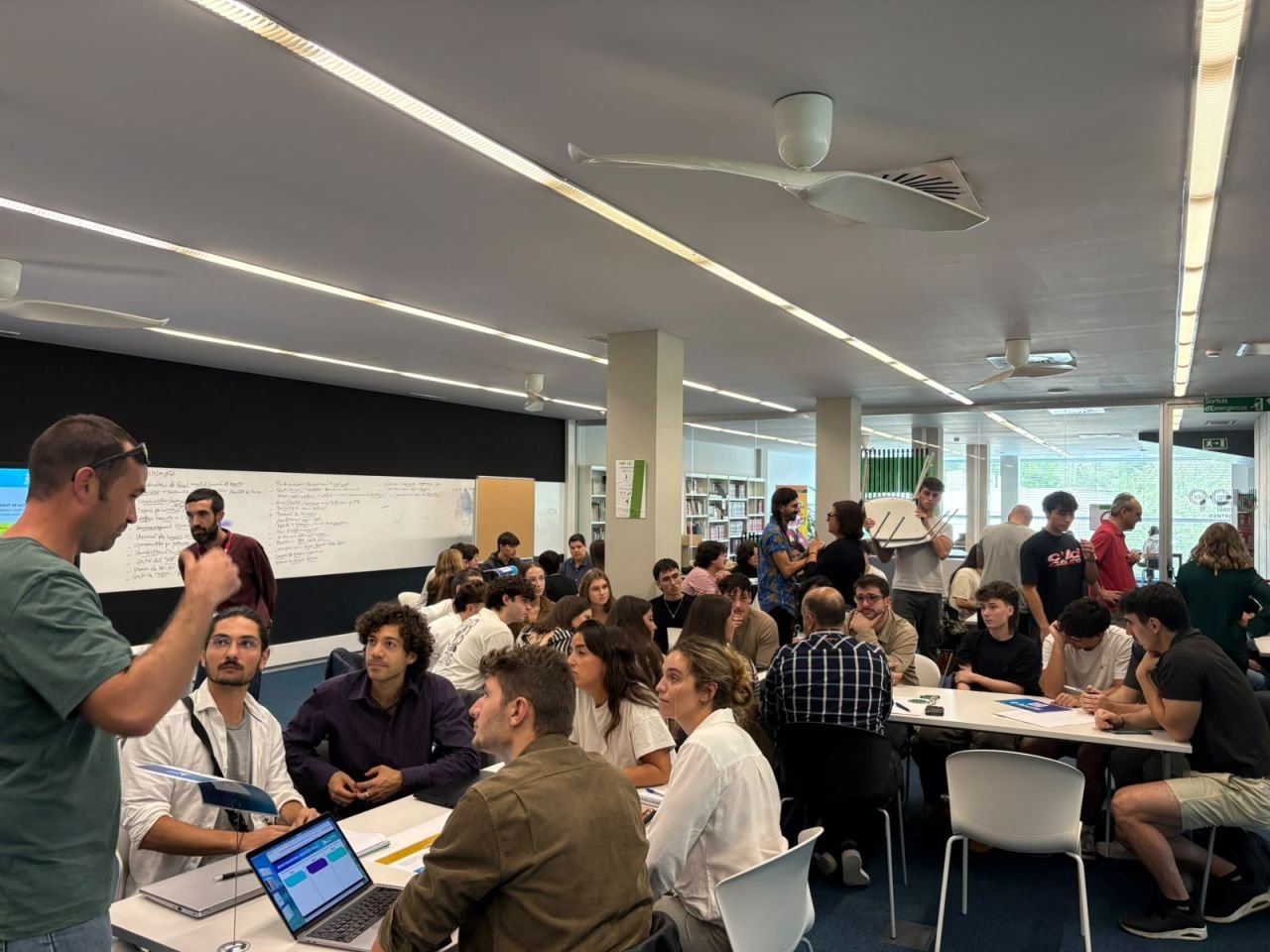 Innovation Day: grupos de estudiantes y profesionales trabajando en mesas